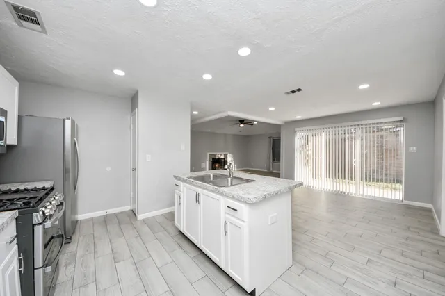 a kitchen with stainless steel appliances granite countertop a stove and a refrigerator