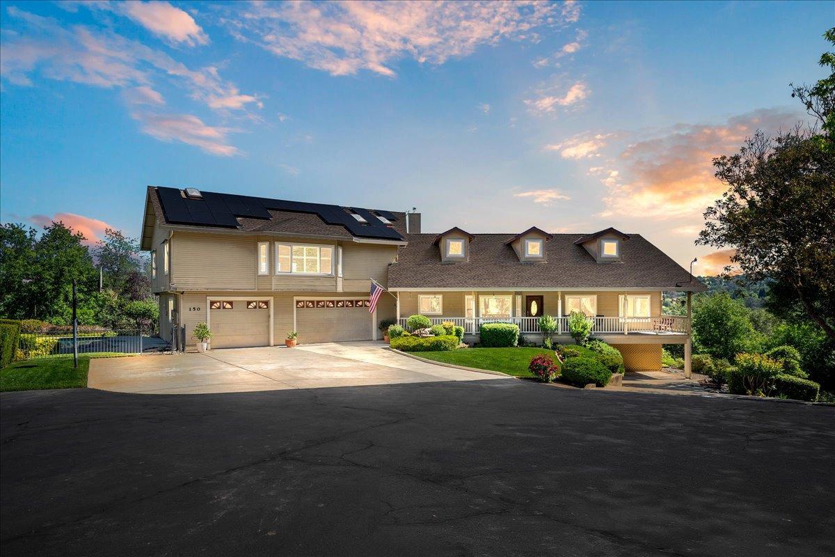 a front view of a house with a garden and yard
