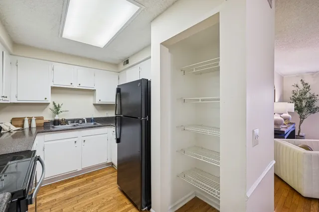 a kitchen with granite countertop cabinets and refrigerator