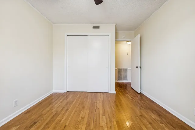 a view of empty room with wooden floor