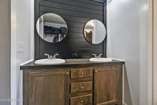 a bathroom with a granite countertop double vanity sink and a mirror