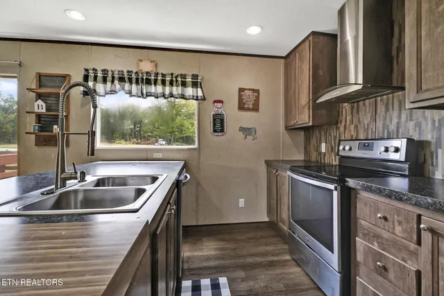 a kitchen with stainless steel appliances granite countertop a sink and a large window