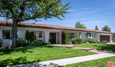 a view of a house with a yard and potted plants