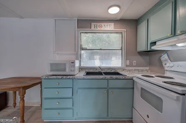 a kitchen with granite countertop cabinets stainless steel appliances and a sink