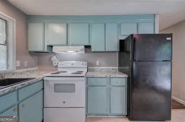 a kitchen with a refrigerator and a sink