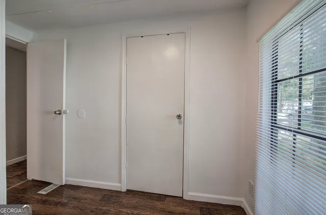 a view of empty room with wooden floor