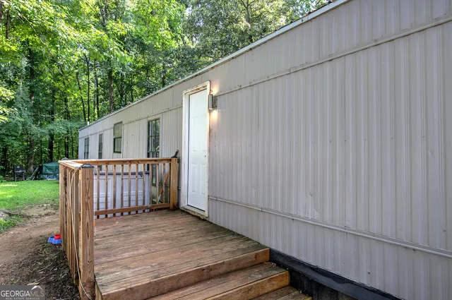 a view of a backyard with wooden floor and fence