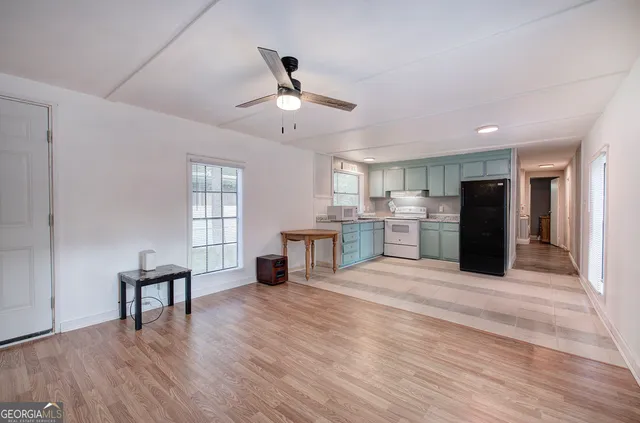 a view of an empty room with window and wooden floor