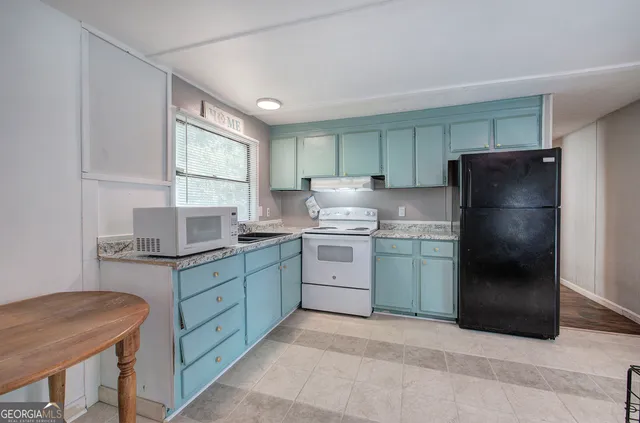 a kitchen with a refrigerator and a stove top oven