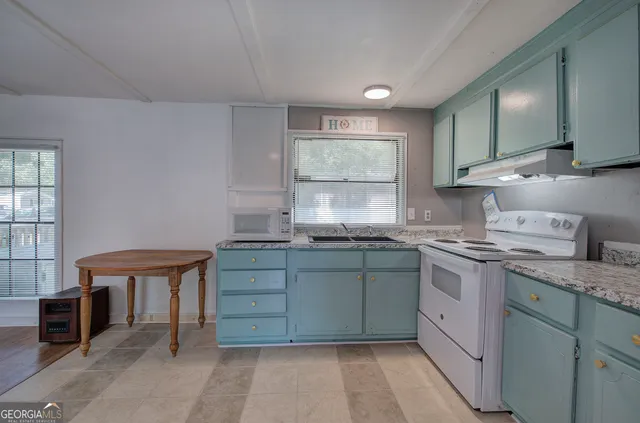 a kitchen with granite countertop a sink and a stove