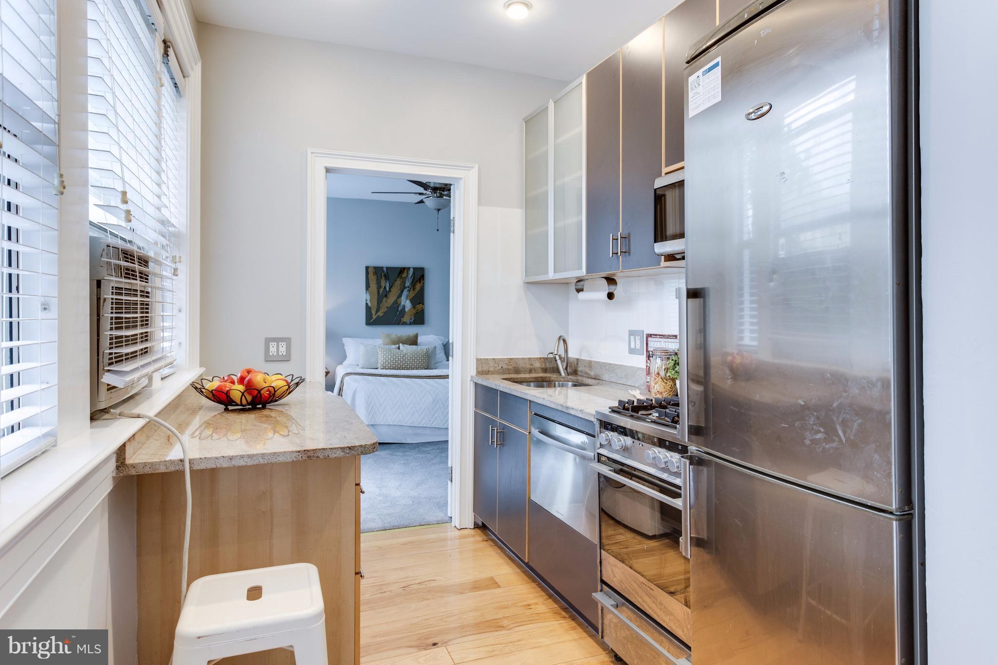 1523 Park Road Northwest, Unit 202 Washington, DC 20010 - Photo 5 of 13 a kitchen with stainless steel appliances a refrigerator stove and sink
