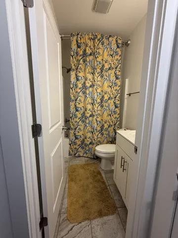 a bathroom with a toilet and a shower curtain