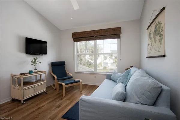 a living room with furniture a flat screen tv and a window
