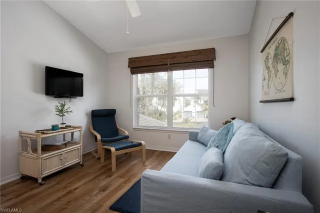 a living room with furniture a flat screen tv and a window
