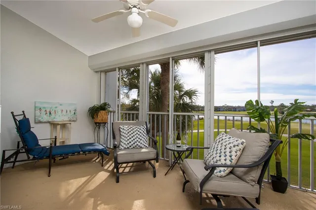 a living room with furniture and a floor to ceiling window
