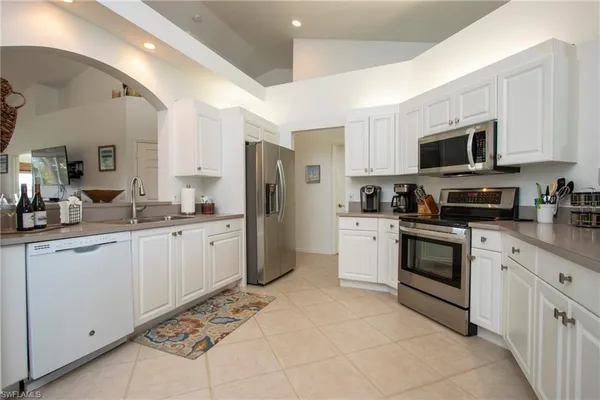 a kitchen with white cabinets and stainless steel appliances