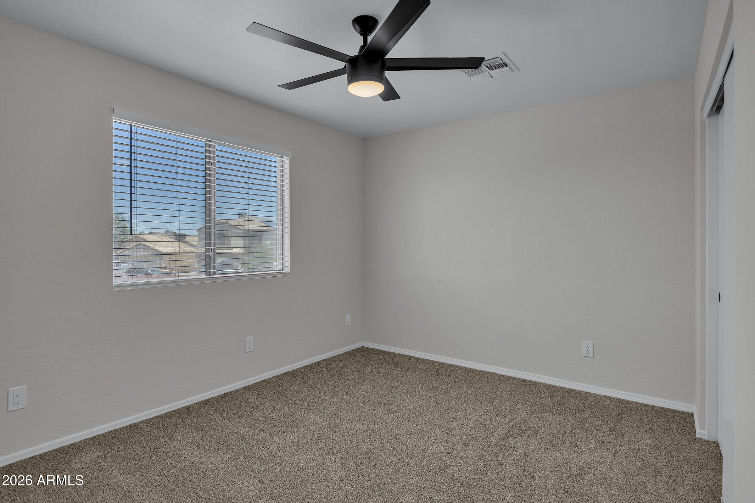 5725 East Good Pasture Lane Florence, AZ 85132 - Photo 22 of 40 an empty room with a window and a fan