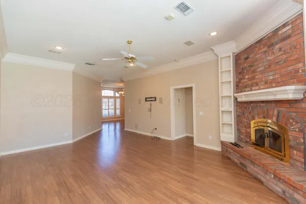 an empty room with windows and chandelier fan