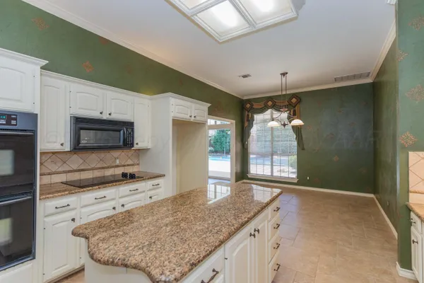 a kitchen with stainless steel appliances granite countertop a sink and a refrigerator