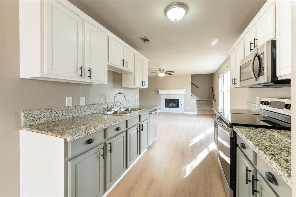 1101 Halifax Lane Forney, TX 75126 - Photo 13 of 32 a kitchen with stainless steel appliances granite countertop a stove and a sink