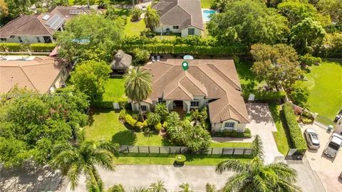 an aerial view of a house with a garden and lake view