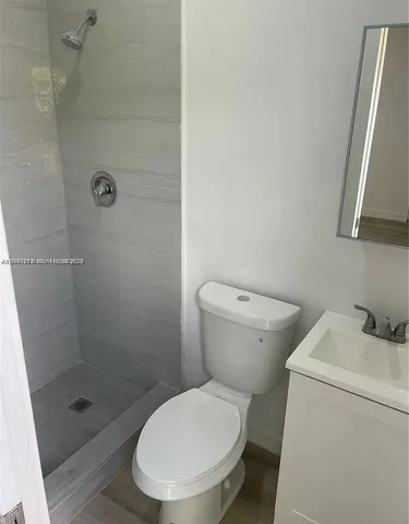 a white toilet sitting next to a shower