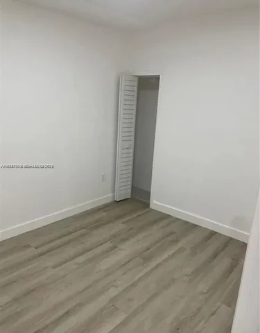 an empty room with wooden floor and closet