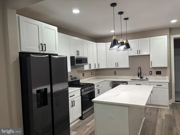 a kitchen with a sink a refrigerator a stove and white cabinets