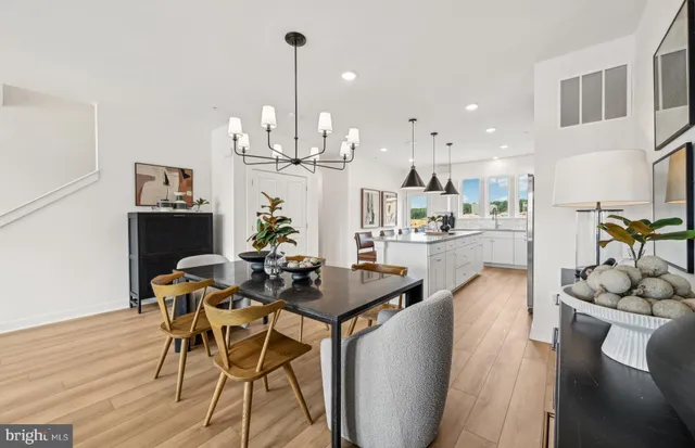 a view of a dining room with furniture a kitchen and chandelier
