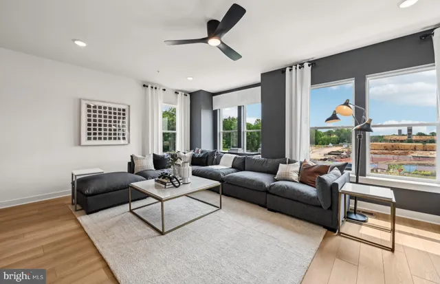 a living room with furniture kitchen view and a large window