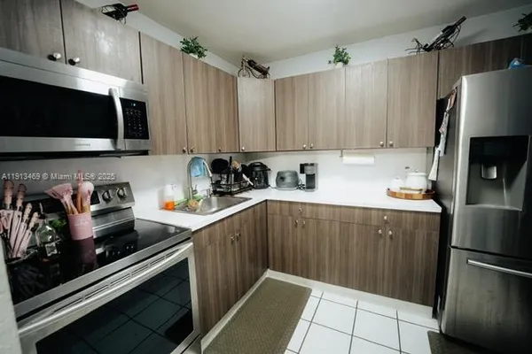 a kitchen with stainless steel appliances a stove a sink a refrigerator and cabinets