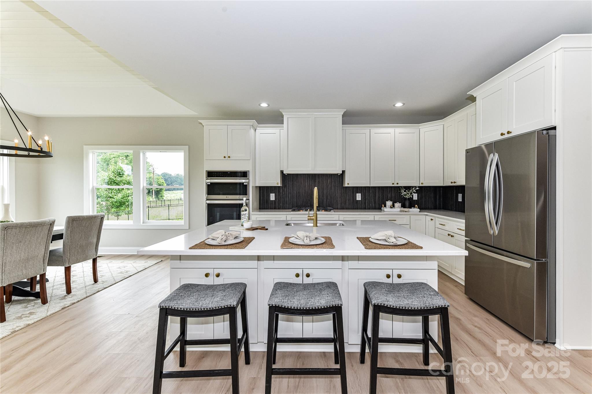 181 Lone Pine Road Statesville, NC 28625 - Photo 12 of 42 a kitchen with stainless steel appliances granite countertop a dining table chairs refrigerator and cabinets