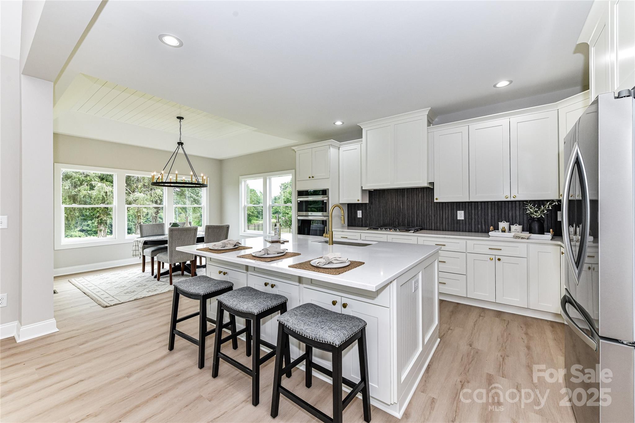 181 Lone Pine Road Statesville, NC 28625 - Photo 13 of 42 a kitchen with a dining table chairs stove refrigerator and cabinets