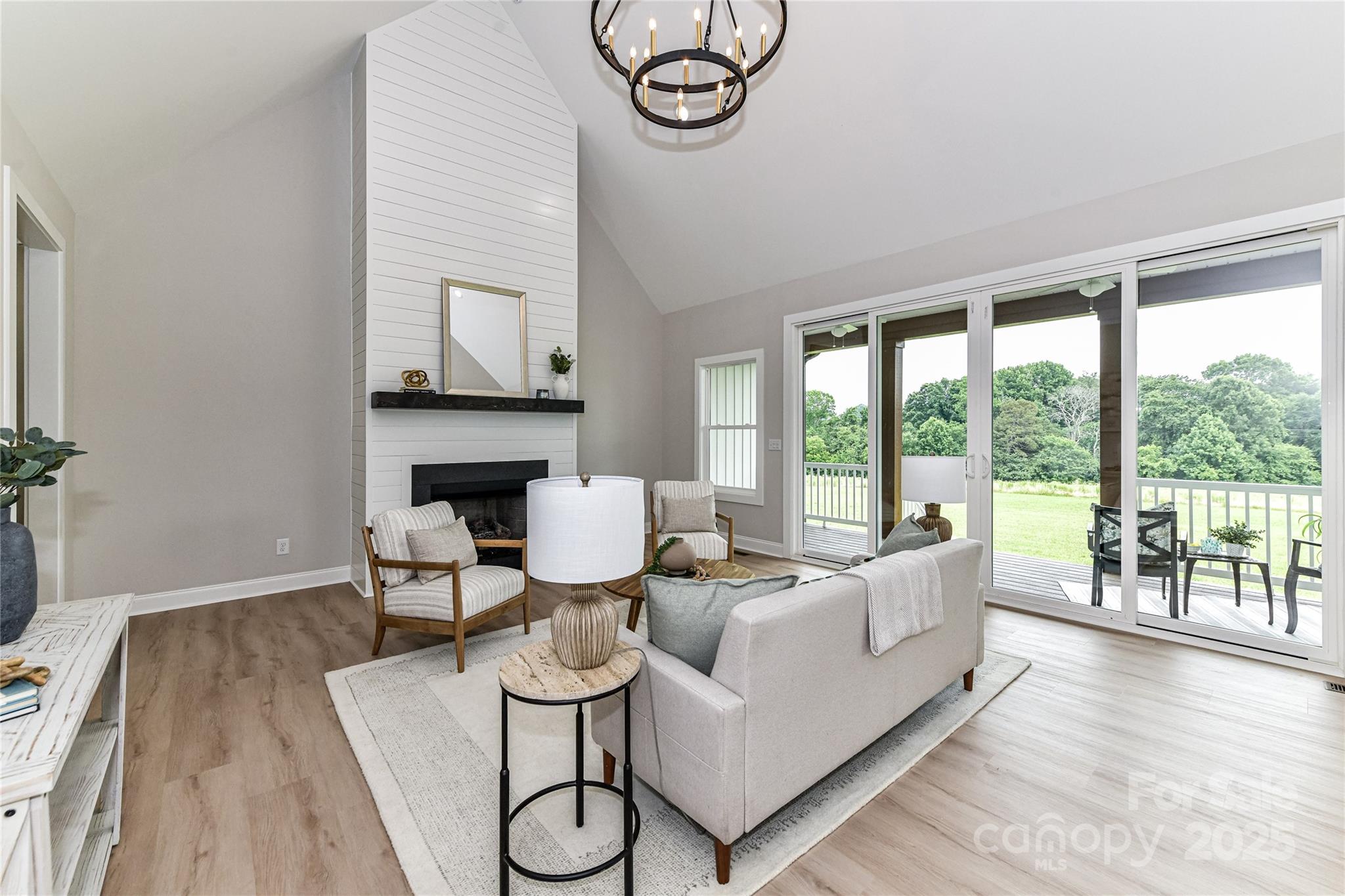 181 Lone Pine Road Statesville, NC 28625 - Photo 10 of 42 a living room with furniture a fireplace and a floor to ceiling window