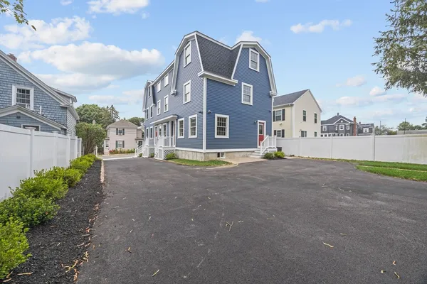 a view of a brick house with many windows and a yard