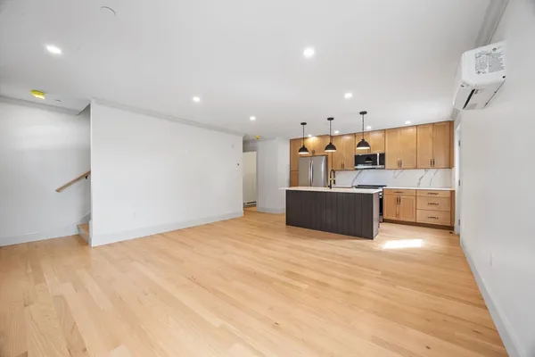 a large kitchen with stainless steel appliances a refrigerator and a sink