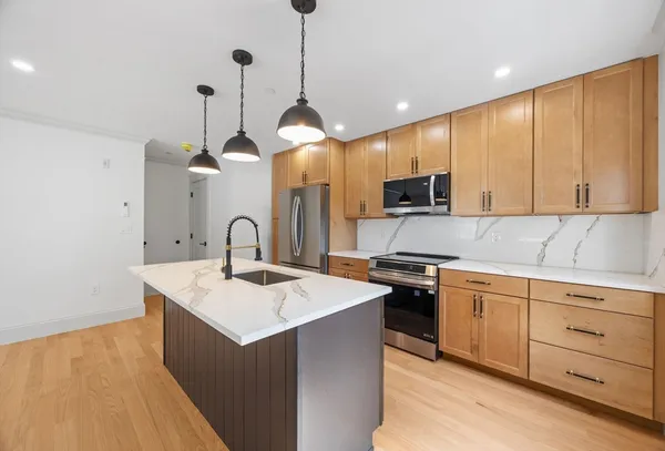 a kitchen with kitchen island a sink stainless steel appliances and cabinets