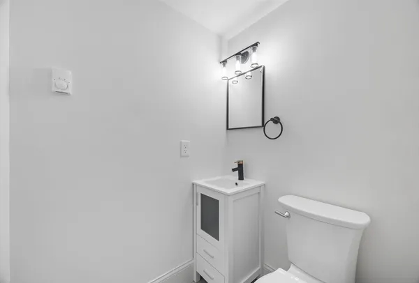 a bathroom with a sink toilet and mirror