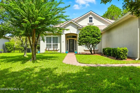 a front view of a house with a yard and trees