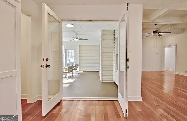 a view of a hallway with wooden floor and closet area
