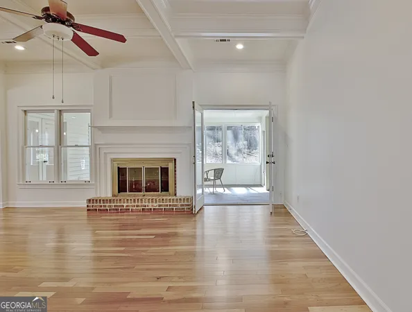 a view of a livingroom with wooden floor and a fireplace