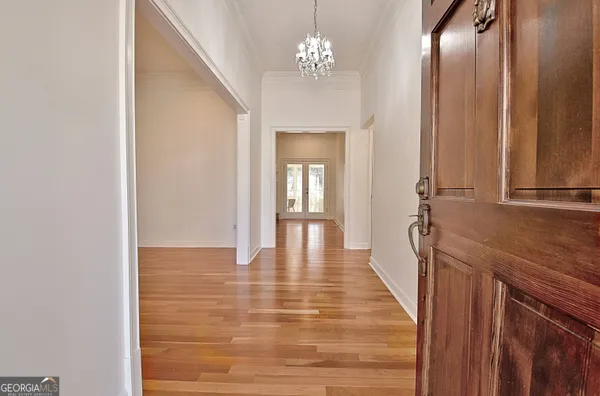 a view of a hallway with wooden floor and staircase