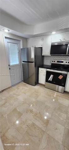 a kitchen with stainless steel appliances a refrigerator and a stove top oven