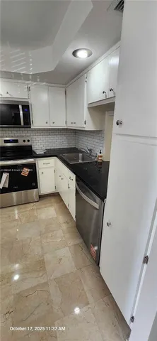 a kitchen with granite countertop a stove sink and cabinets