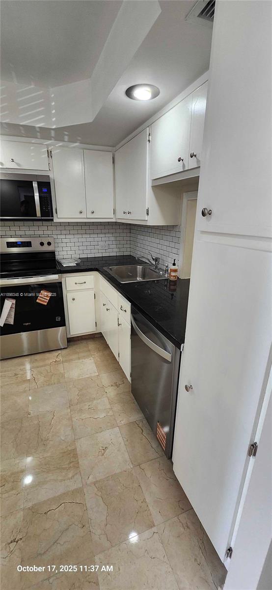 443 Northeast 195th Street, Unit 238 Miami, FL 33179 - Photo 3 of 15 a kitchen with granite countertop a stove sink and cabinets