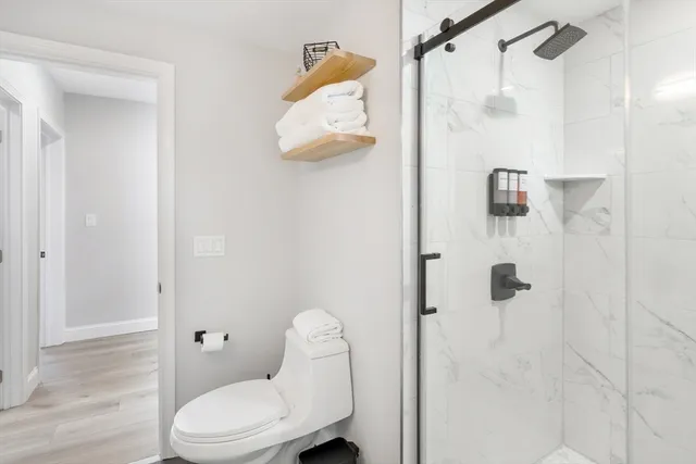 a white toilet sitting next to a bathroom shower
