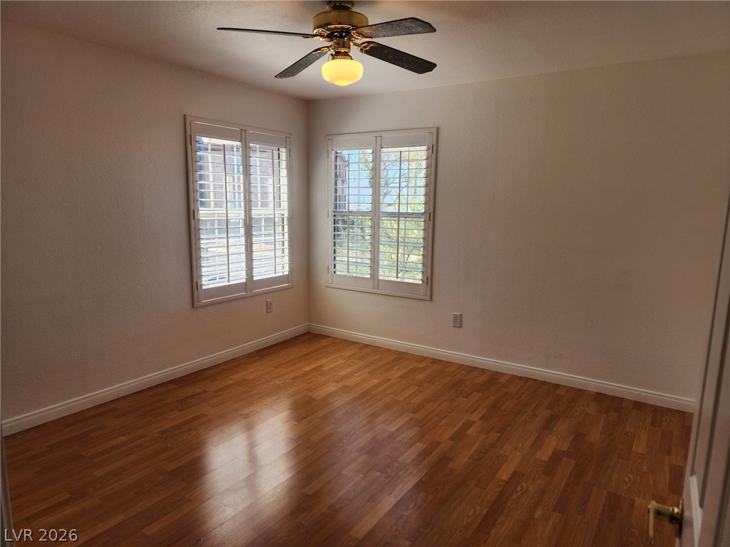231 West Horizon Ridge Parkway, Unit 1127 Henderson, NV 89012 - Photo 23 of 39 Well-lit room featuring rich wood flooring and practical window shutters for adaptable light control.