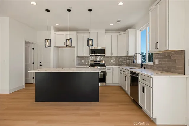 a kitchen with stainless steel appliances granite countertop a stove a sink and a refrigerator