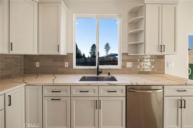 a kitchen with kitchen island granite countertop a sink and cabinets