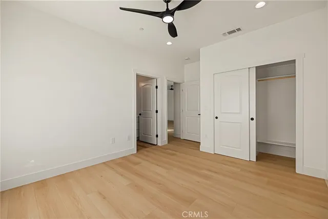 a view of a livingroom with a ceiling fan & entryway